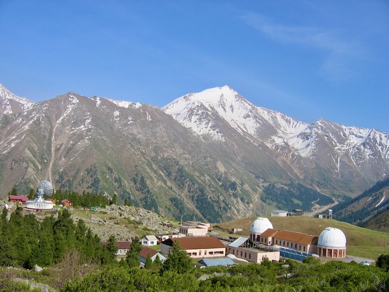 Tien Shan Astronomical Observatory and snow-covered mountain peaks above Big Almaty Lake, Kazakhstan