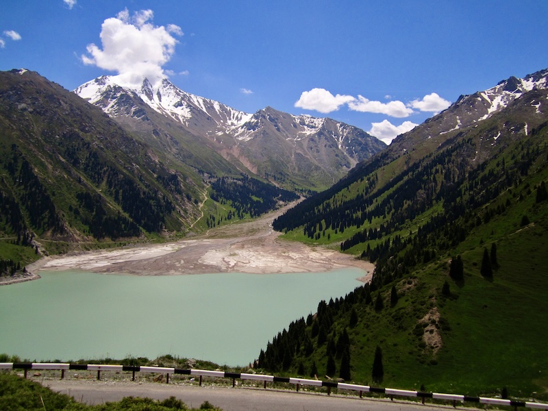 Big Almaty Lake at low water level, surrounded by spruce forests and snow-covered peaks, Zailiyskiy Alatau