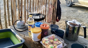 Breakfast being prepared at an outdoor camping kitchen in Aktau Mountains