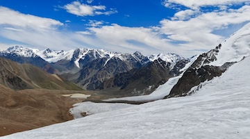 Panoramic view of glaciers, snowy peaks and rugged mountain valleys along a high-altitude trekking route